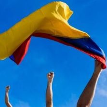 hochgestreckte, zur Faust geballte Hände als Zeichen des Protests, eine mit kolumbianischer Fahne